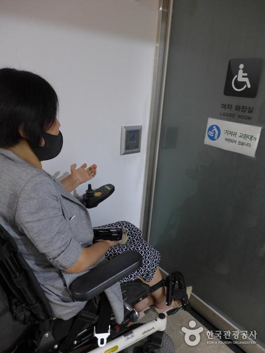 장애인화장실 자동문 스위치의 위치가 휠체어 팔걸이 높이에 맞게 좀 더 낮아야 하며 팔을 뻗지 않아도 되도록 앞쪽으로 위치해야 한다