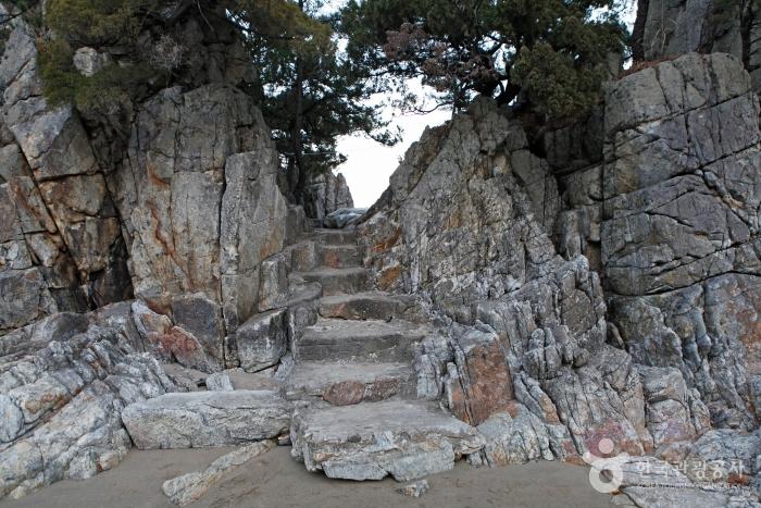 서래와 해준이 차례로 걸어 들어간 바위산 입구