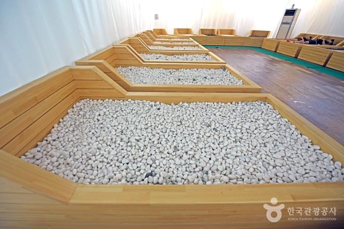 스톤테라피용 나무 침대를 채운 몽돌